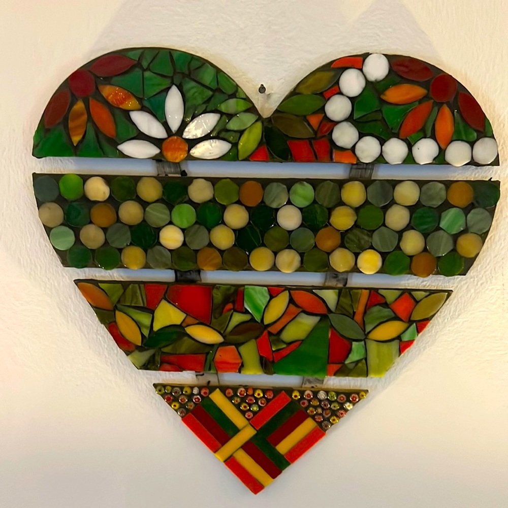 Heart shape wood like base with mosaic artwork on top.